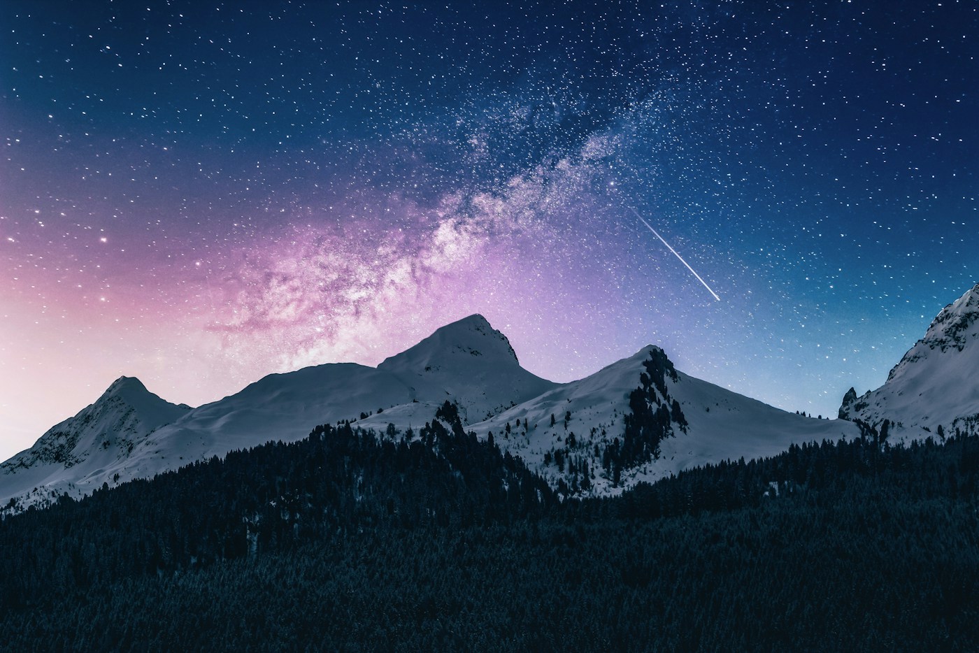 A star-filled blue and purple sky above mountain peaks